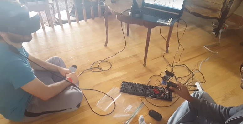 Augmented Education demonstration with a VR headset user beside the team's robotic arm.