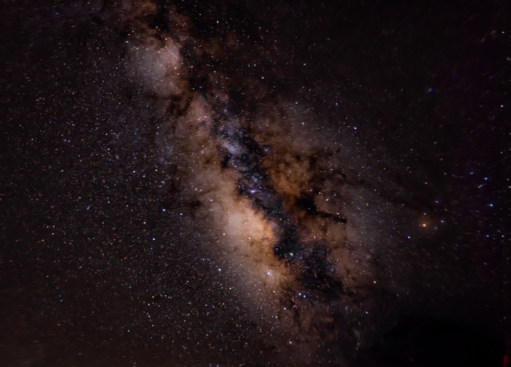 Dense stars and dark dust lanes across the glowing Milky Way.